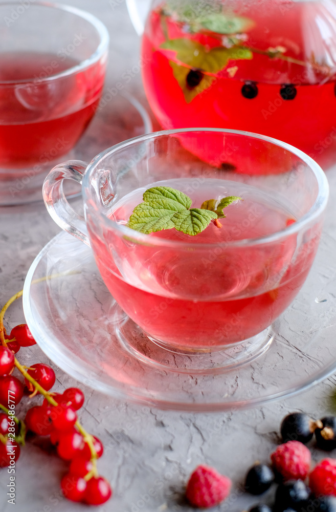 Fruits red tea with a berries in glass cup on gray cement background Fruits red tea with a berries in glass cup on gray cement background