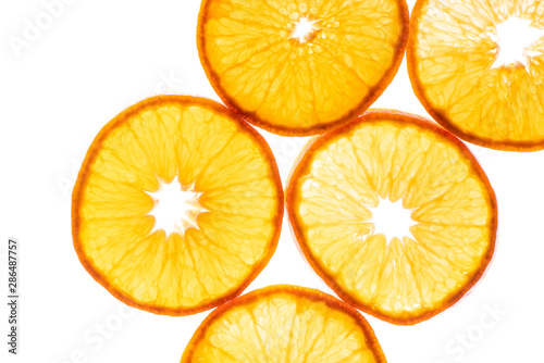 Macro photo of slices of juicy orange with back light isolated on white background. Top view