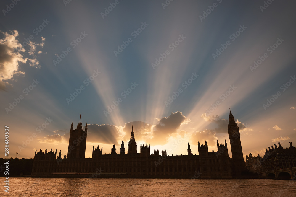 Dramatic sun beams behind the Palace of Westminster as the sun sets in London.