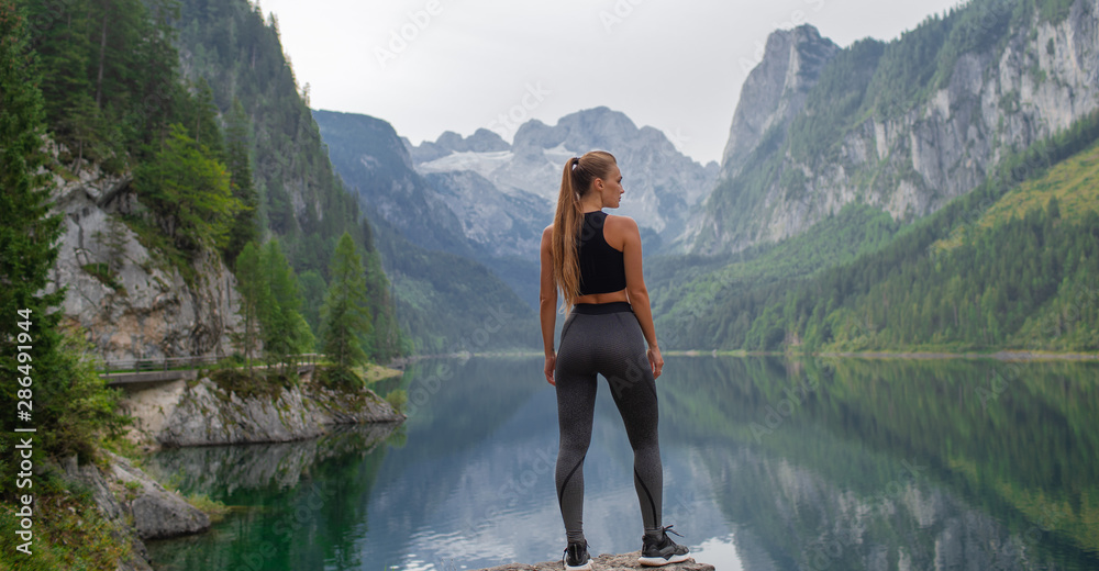Young sexy athletic girl in the mountains near the lake - obrazy, fototapety, plakaty 