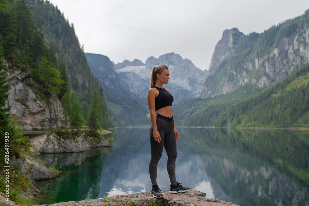 Young sexy athletic girl in the mountains near the lake