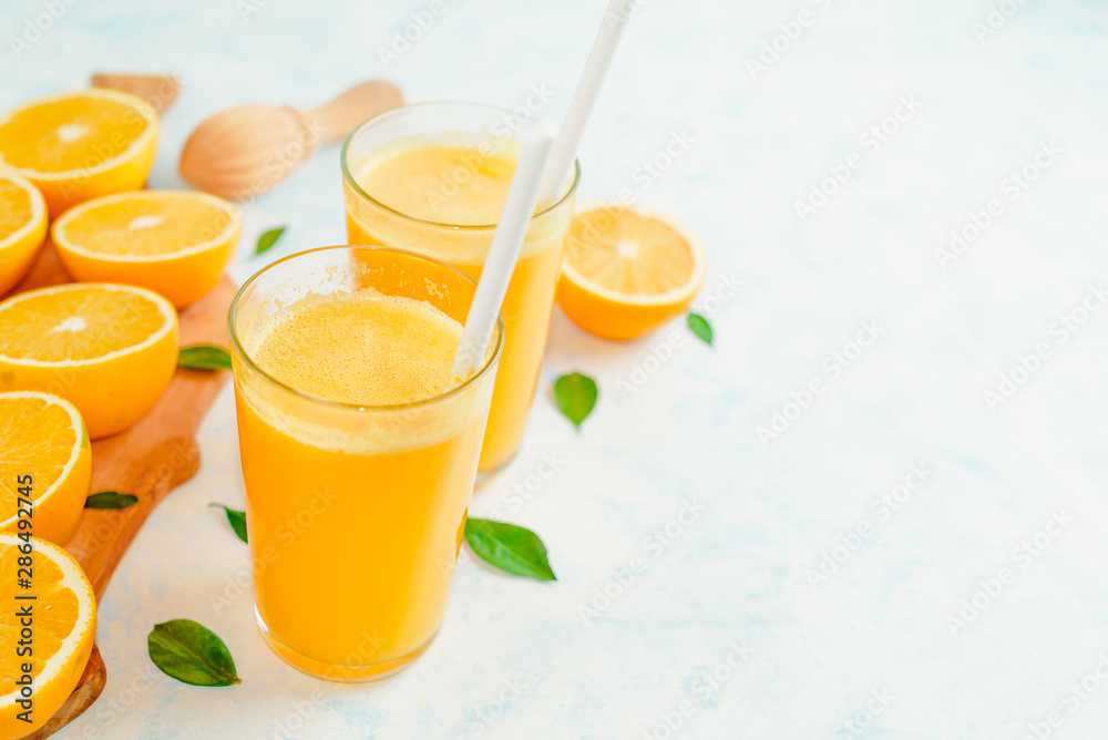 Fototapeta premium Orange juice and orange fruits with green leaves on white background.