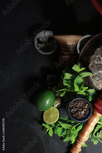 bowl with tobacco for hookah. fruits on a black background. smoking hookah