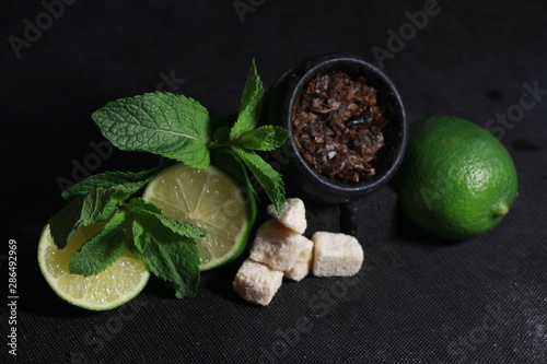 bowl with tobacco for hookah. fruits on a black background. smoke hookah
