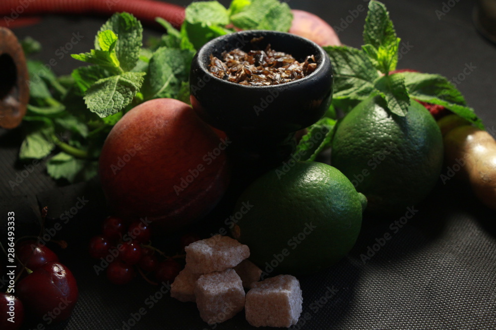 bowl with tobacco for hookah. fruits on a black background. smoking hookah bowl with tobacco for hookah. fruits on a black background. smoking hookah