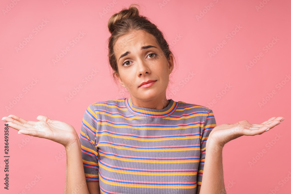 Image closeup of perplexed young woman wearing casual clothes shrugging and throwing up hands Image closeup of perplexed young woman wearing casual clothes shrugging and throwing up hands