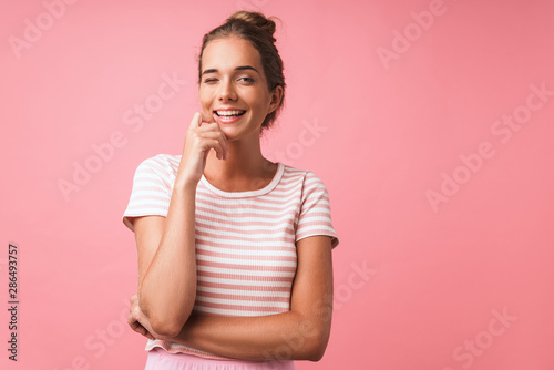 Image of lovely beautiful woman wearing striped clothes smiling and winking at camera