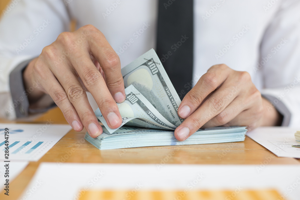 Toned picture,Men using hands to count dollar bills Toned picture,Men using hands to count dollar bills