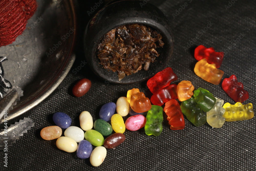 bowl with tobacco for hookah. fruits and berries on a black background. smoke hookah bowl with tobacco for hookah. fruits and berries on a black background. smoke hookah