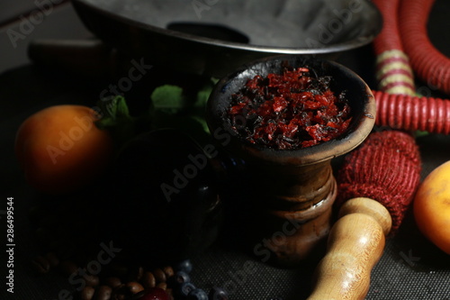 bowl with tobacco for hookah. fruits on a black background
