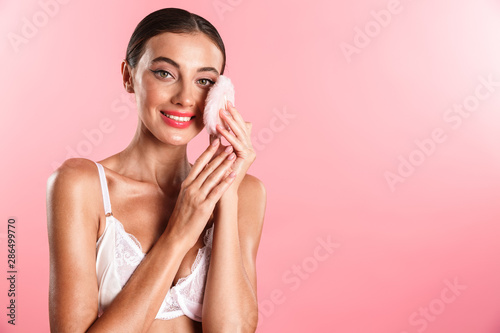 Image of lovely shirtless woman wearing white sexual lace lingerie holding powder puff