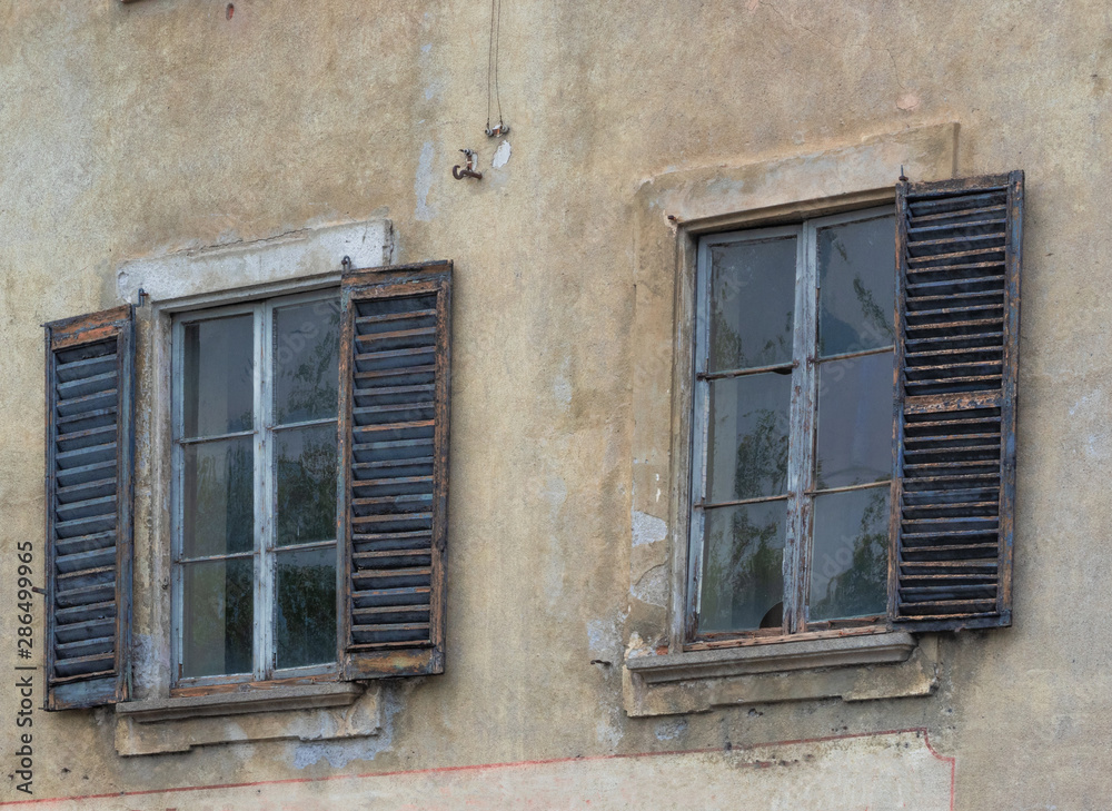 old windows on the facade of a ruined house