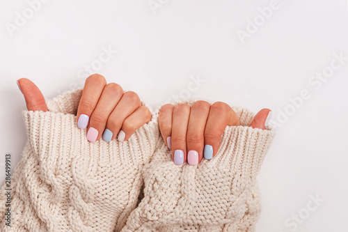Woman's hands with proffesional manicure in pastel colors