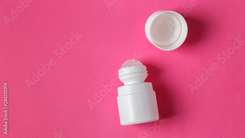 White roll on deodorant on pink background