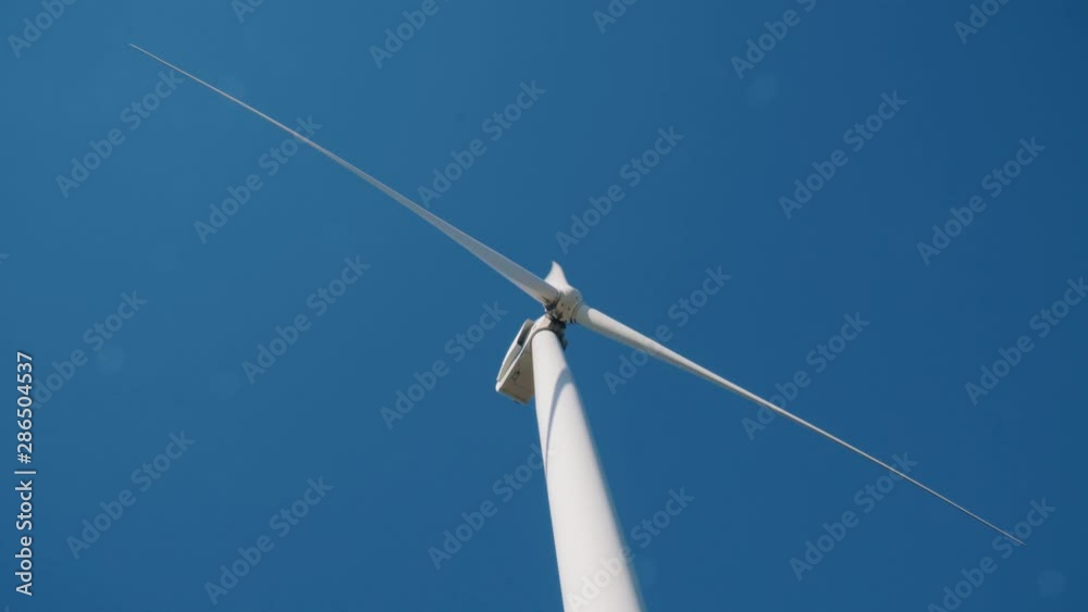 White wind energy tower mill against the blue sky. Green, clean, renewable energy White wind energy tower mill against the blue sky. Green, clean, renewable energy