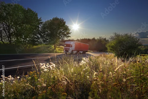 Obraz Transport ciężarowy na drodze o zachodzie słońca i ładunku