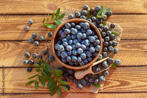 Pile and bowl with fresh blueberries on wooden background. Top view.