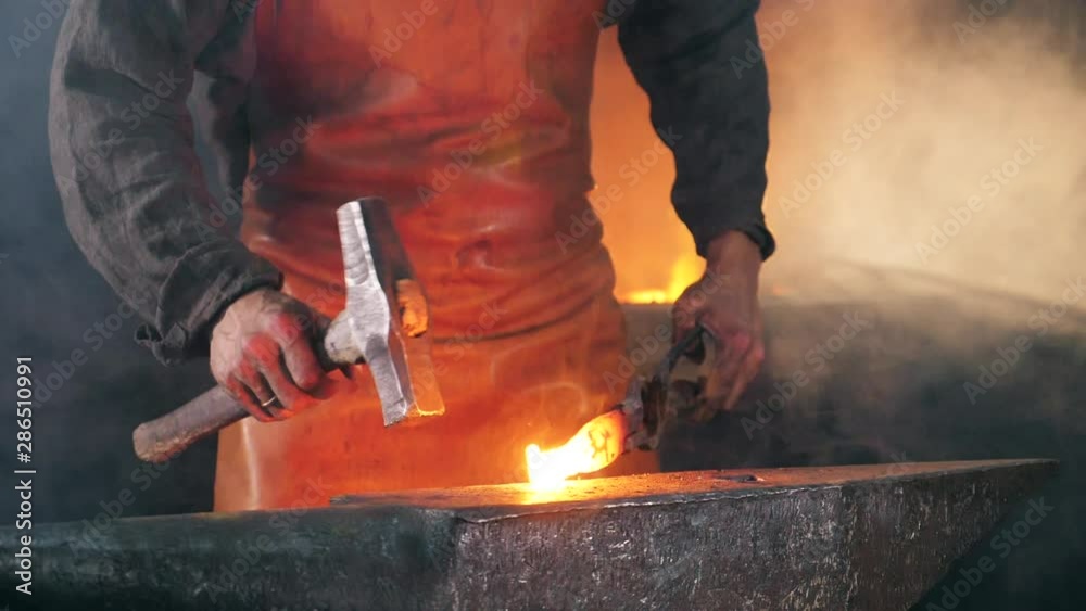 Slow motion of the blacksmith forging iron Slow motion of the blacksmith forging iron