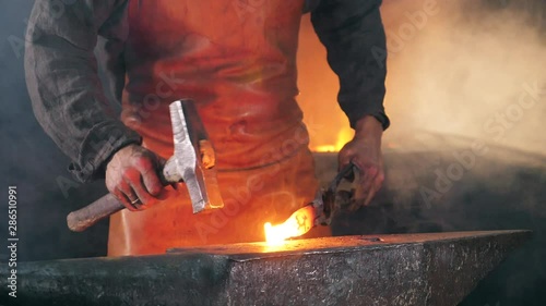 Slow motion of the blacksmith forging iron