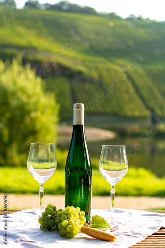 Famous German quality white wine riesling, produced in Mosel wine regio from white grapes growing on slopes of hills in Mosel river valley in Germany