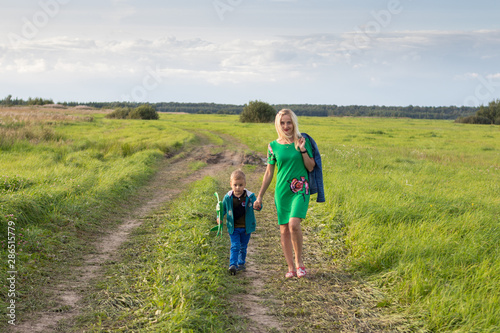 mom and son walk on a rural road