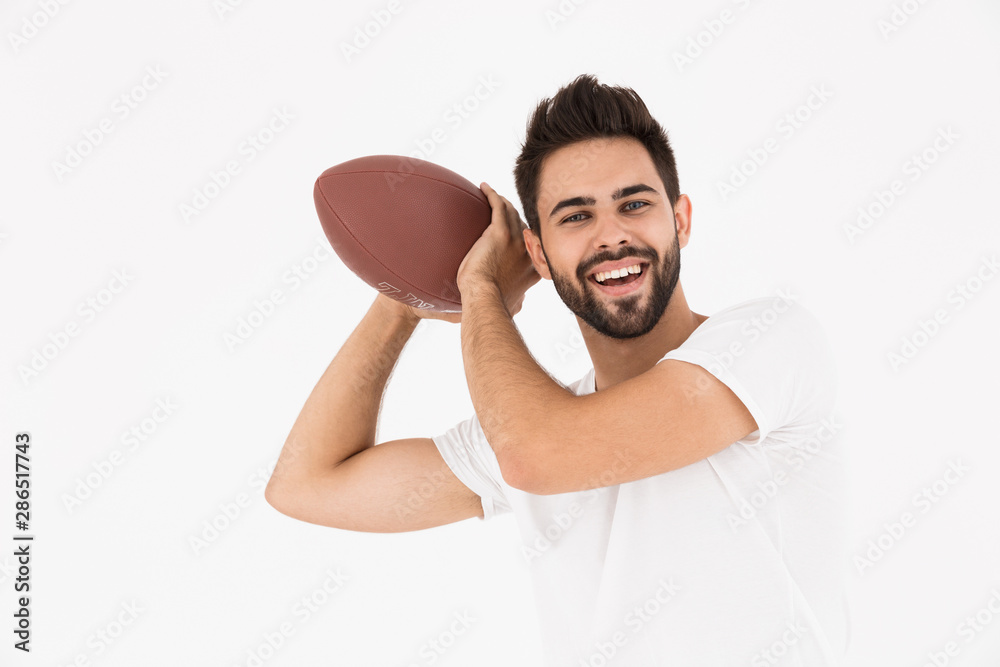 Image of young handsome man holding rugby ball and smiling Image of young handsome man holding rugby ball and smiling