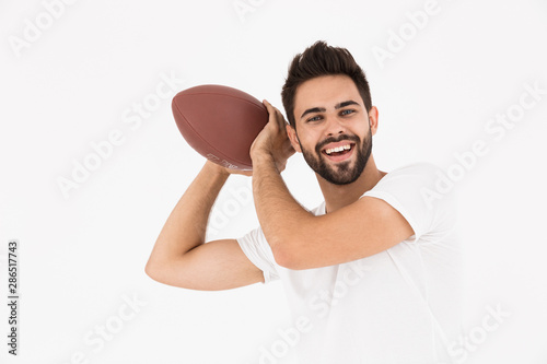 Image of young handsome man holding rugby ball and smiling © Drobot Dean
