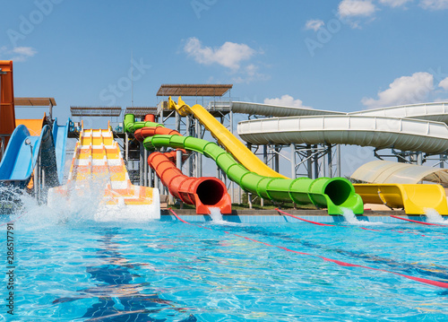 Obraz na plátně Water park, bright multi-colored slides with a pool