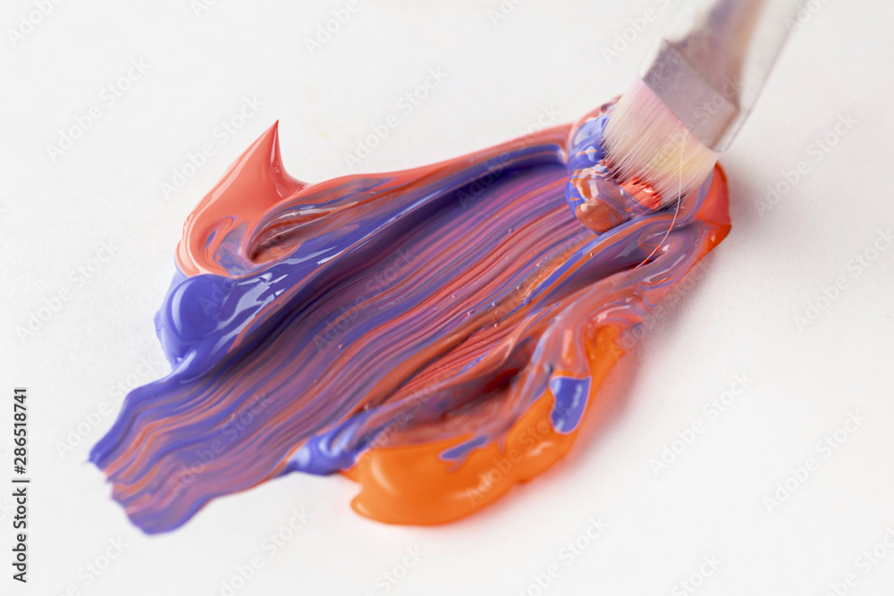 Mixed orange and blue paint with brush