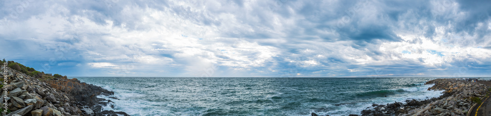 Panoramic view of ominous cloud formations on the coast.