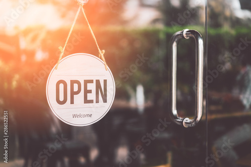 Open sign hanging front of cafe with colorful bokeh light abstract background. photo