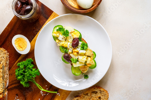Open sandwich with traditional German potato salad, bread, eggs, olives, top view