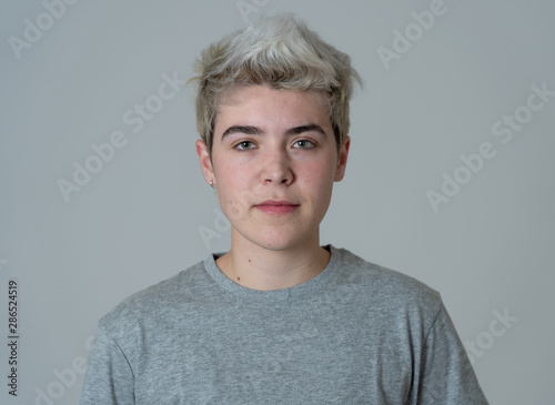 Natural portrait of young handsome transgender boy posing with neutral face expression