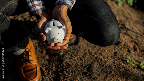 Small white piggy bank in a hands in the morning