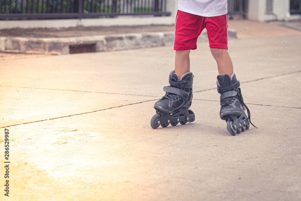 Child playing rollerblading in the Cement road