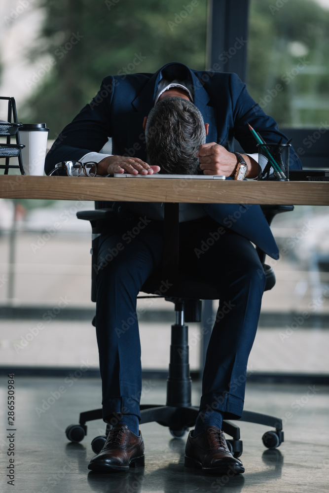 man sitting near desk with paper cup in modern office man sitting near desk with paper cup in modern office