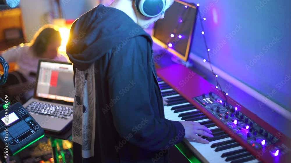 a musician stands in front of a synthesizer