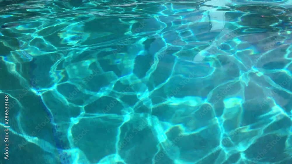 Water abstract background, Swimming pool rippled. Hotel swimming pool with sunny reflections Water abstract background, Swimming pool rippled. Hotel swimming pool with sunny reflections