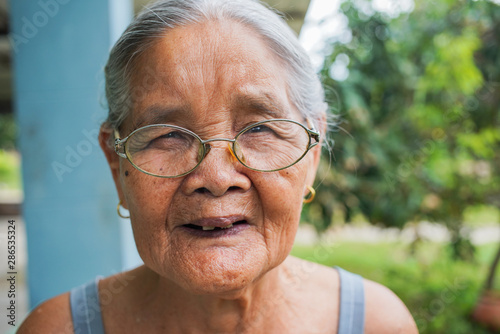 Close-up, Asian senior elderly 81s-89 year woman wearing glasses is face smiling at home