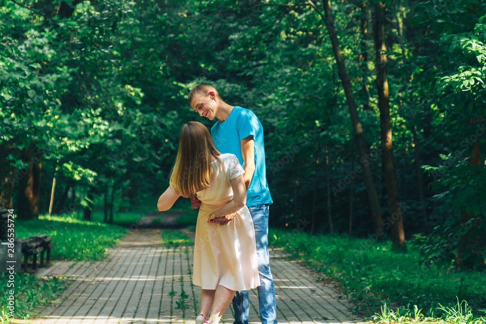 Fototapeta premium A guy and a girl are walking in the park