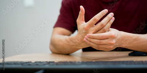 close up employee man massage on his hand and arm for relief pain from hard working ,carpal tunnel syndrome concept	 photo