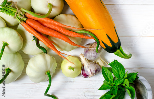 Harvest. Patisons, garlic, carrots, basil, lentils and zucchini lie on a blue wooden table photo