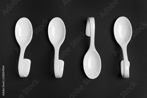 Ceramic serving spoons on black background, flat lay