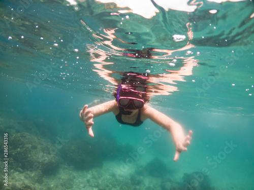 Underwater portrait of a woman snorkeling in tropical sea.