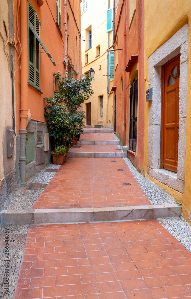 Obraz premium Menton. Old narrow street in the historic part of the city.