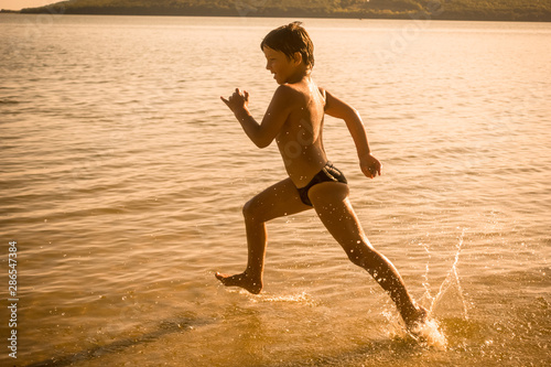 boy running on the water with splashes
