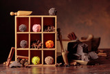 Chocolate truffles with broken pieces of chocolate and spices in wooden box.