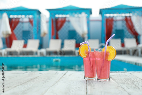 Refreshing cocktails near outdoor swimming pool on sunny day
