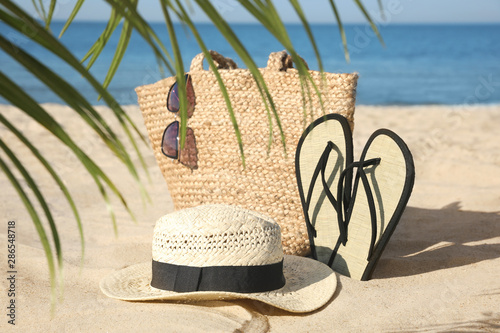 Stylish beach accessories on sandy sea shore photo