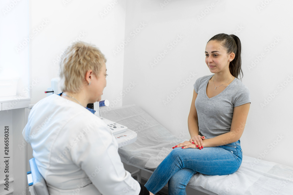 Professional doctor advises the patient young girl after ultrasound Professional doctor advises the patient young girl after ultrasound
